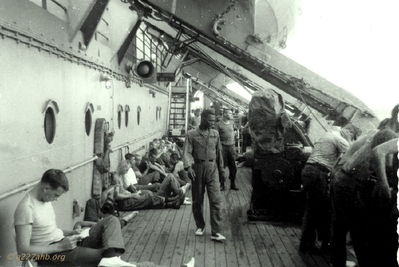 George Klein (Seated) Reading
Robert Keller Photo

Onboard Ship to Vietnam
I do not remember the name of the ship. I think this picture taken of George Klein aboard ship was pre Panama Canal crossing. When going through the canal we stopped in the canal in I believe Panama. We had a captain aboard whose wife was the daughter of the governor and we stopped there. I forget the captains name. He was an extremely nice person.


