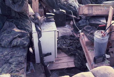 Our area on the morning after
Bob Kelly Photo

My Carbine. Our refridgerator. sprayer for agent orange. Tent knocked down. Our bunker facing ammo dump. Ernie and I back from battalion luckily did not step on live ammo or geet shot by friendlies.
