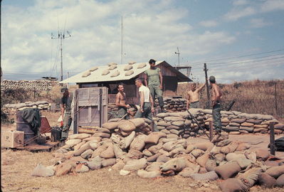 Repairing Bunker at LZ English
Bob Kelly Photo

Ernie Kramer, 1st Platoon Leader Jim Kanzenbach and Lazo repairing bunker.
