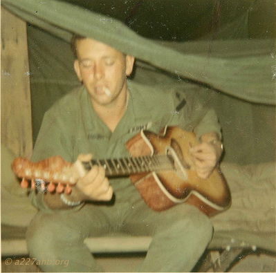 Eddings playing guitar in tent
Rickey McKay photo

 We called him Bengie I think but his last names is Eddings I believe he was from Alabama 
