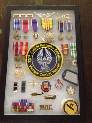 Display Case 1
Robert Kelley Photo

These are three different displays, one for each grand child. I wanted each different. The wings and medals remain at the top for each but anything goes after that. The Huey & Hook, Pouvoir and Garry Owen were all there.  I am mixing a few different items in for each child.
