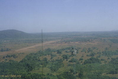 LZ Oasis, on final to parking right of trees, December 1966.
John Keller Photo

LZ Oasis is located on the road to DUC CO from PLEIKU. As you flew down the road, southwest of Pleiku, the first major area was â€œTEA PLANTATIONâ€ or CATECKA. Further west was a place along the road shown as PLEI RONGOL that became LZ OASIS (about 25 â€œclicksâ€ from Pleiku). About another 25 â€œclicks was DUC CO. While at LZ OASIS, we staged out of there to intercept the PAVN troops coming down the Ho Chi Minh Trail. 
