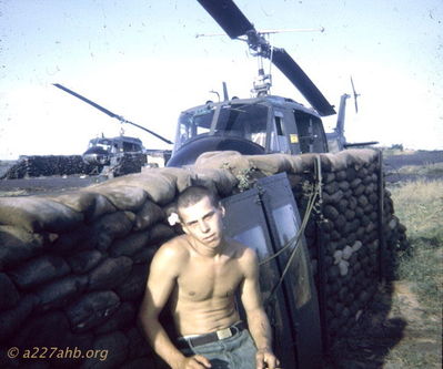John Rush on flight line
Richard Penny Photo

This "Flower Child" was leaning against the revetment wall asleep, so I slipped the wild flower above his ear and snapped this shot. He also feel asleep in the barber's chair a few days earlier. Phan Thiet late 1967.
