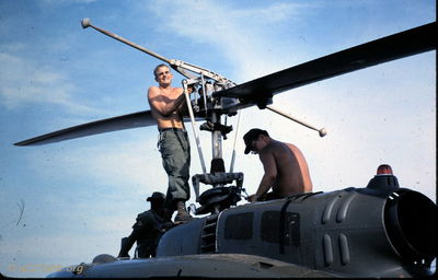 Maintenance Crew at Phan Thiet
Jerry Westenskow Photo

Maintenance at Phan Thiet, I don't have names for these guys.
From John Woods:  "the person standing working on the rotor head is me, John Woods. At that time it was SP5 John Woods. "

